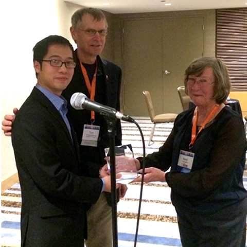 Karen Jahns presenting award to Denny Yu. Dr. Tom Armstrong, Yu's advisor, is also present.